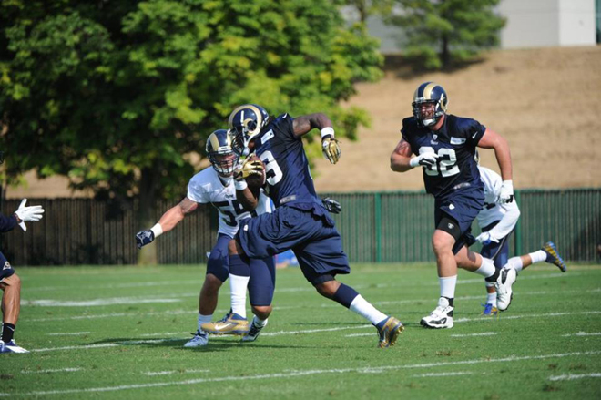 SJ braces for contact after breaking a carry into the open field at practice.